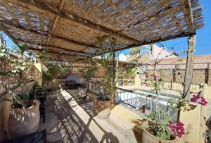 een patio met potplanten en een pergola bij Riad Slima en exclusivité petits déjeuners compris in Marrakesh