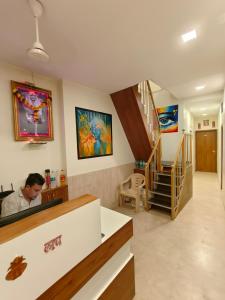 a man sitting at a counter in a room at Hotel Beach Crown Juhu in Mumbai