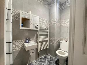 un piccolo bagno con servizi igienici e lavandino di Room with private bathroom and shared kitchen a Londra