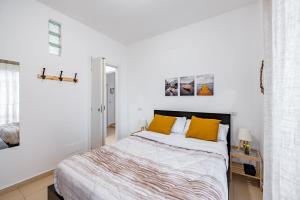 een witte slaapkamer met een bed met gele kussens bij The Base - Comfort a Milano in Milaan