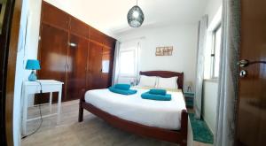 Un dormitorio con una cama con almohadas azules. en Sunset View Flat en Aljezur