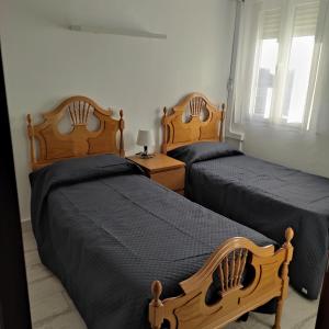 two twin beds in a bedroom with at Apartamento Altomira in Buendía