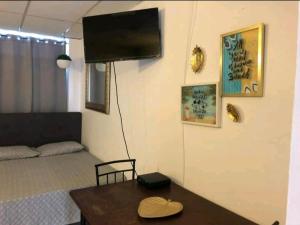ein Wohnzimmer mit einem Tisch und einem TV an der Wand in der Unterkunft Verdemar Apts in San Juan