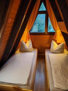 2 camas en una habitación pequeña con ventana en Ferienhaus mit Seeblick en Waldkirchen