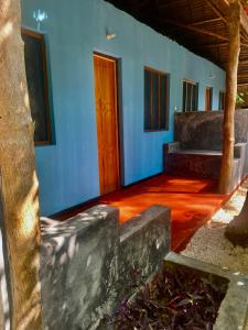 Habitación con paredes azules y suelo de madera. en Milele Lodge, en Michamvi