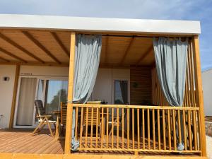 a small house with a porch with curtains at SUN&MOON in Drage