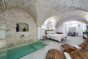 a room with a swimming pool and a bedroom at Gattoni Suite by Rentbeat in Martina Franca