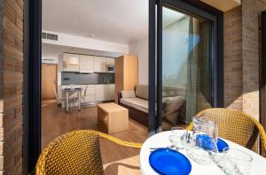 a dining table with chairs and a living room at Almirall Apartaments in Lloret de Mar
