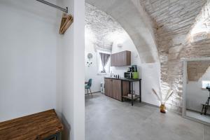 Il comprend une cuisine et un salon avec un mur en pierre. dans l'établissement Gattoni Suite by Rentbeat, à Martina Franca