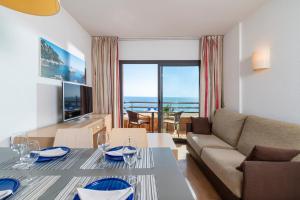 a living room with a couch and a table at Almirall Apartaments in Lloret de Mar
