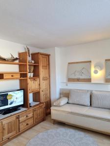 uma sala de estar com um sofá e uma televisão em Appartement Erich Schweiger em Sankt Anton am Arlberg