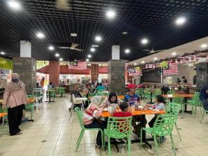 un grupo de personas sentadas en una mesa en un restaurante en HomeStay D 11 Putrajaya NETFLIX WIFI en Putrajaya