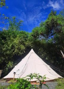 a large white tent sitting next to some trees at JUSH NATIVE AND GLAMPING in Dauis