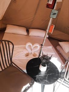 einen Tisch mit einer Pflanze und einer Lampe in einem Zelt in der Unterkunft JUSH NATIVE AND GLAMPING in Dauis