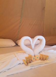 two swans making a heart on a bed at JUSH NATIVE AND GLAMPING in Dauis