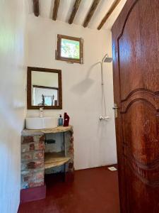 a bathroom with a sink and a mirror at Dreamland Bungalows Michamvi Kae in Michamvi