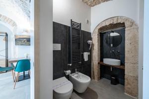 a bathroom with a white toilet and a sink at Gattoni Room by Rentbeat in Martina Franca
