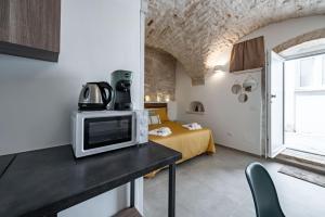 a room with a bed and a microwave on a counter at Gattoni Room by Rentbeat in Martina Franca