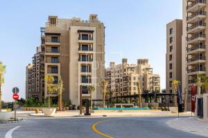 an empty street in a city with tall buildings at Chic 2 Beds With Pool View Asayel B3 MJL in Dubai