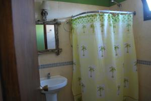 a bathroom with a shower curtain with palm trees on it at Terrazas de Aguas Dulces in Aguas Dulces +82 photos