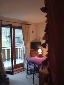 a room with a table with a lamp and a sliding glass door at LE CROQ NEIGE in Bernex