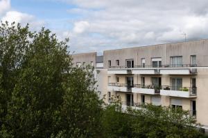 an apartment building with trees in front of it at T2 très bien situé-refait-Balcon aménagé-box clos in Rennes