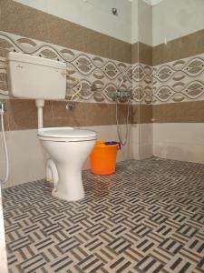 W pokoju znajduje się łazienka z białą toaletą. w obiekcie Dubai Hotel & Restaurant Kumarakom w mieście Kumarakom