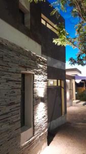 a brick building with a door on the side of it at Acacias Mina Clavero in Mina Clavero