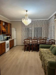 una cucina e una sala da pranzo con tavolo e sedie di Garden House a Almaty