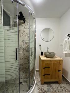 a bathroom with a glass shower and a sink at Corinto Tiny House in Paipa