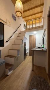Habitación con escaleras y cocina con mesa. en Corinto Tiny House en Paipa