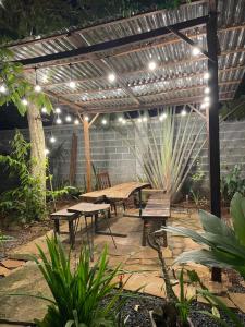 a patio with benches and a pergola with lights at Gỗ Homestay khu sinh thái Akodhong và trung tâm BMT in Buon Ma Thuot