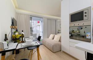 a living room with a white couch and a table at Apartamentos do Mar - Pikis Flat in Funchal