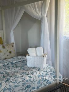 1 dormitorio con cama con dosel y cortinas blancas en Sunbonani Lodge en Maputo