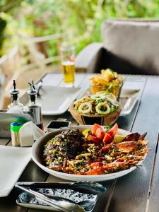 a table with a plate of food on top of it at Sunbonani Lodge in Maputo