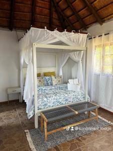 a bedroom with a bed with a canopy at Sunbonani Lodge in Maputo