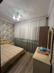 1 dormitorio con cama, mesa y ventana en Garden House en Almaty