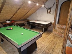 a room with a pool table and a piano at Chalupa Střítež in Vělopolí