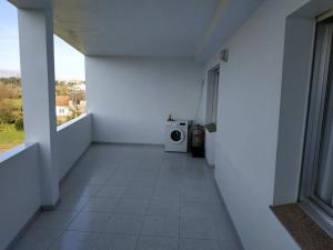 um corredor com uma máquina de lavar roupa num quarto branco em Piso luminoso con enorme terraza y buenas vistas em Carballo