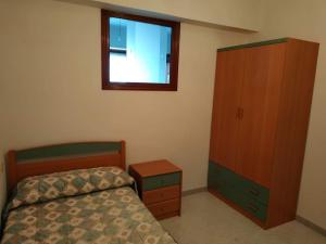 um quarto com uma cama, uma cómoda e uma janela em Piso luminoso con enorme terraza y buenas vistas em Carballo