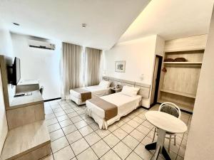 a hotel room with two beds and a television at Alagoinhas Plaza Hotel in Alagoinhas