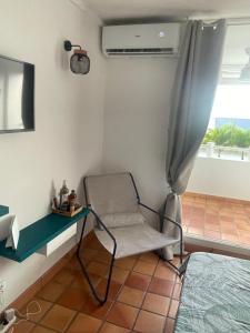 a room with a chair and a bed and a television at Studio Martinique Ti Family in La Trinité