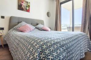 a bedroom with a bed with a blue and white comforter at résidence hivernage, couples mariés in Agadir +14 photos