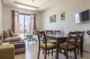 ein Wohnzimmer mit einem Esstisch und Stühlen in der Unterkunft résidence hivernage Quartier Sonaba in Agadir