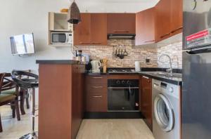 a kitchen with a stove and a dishwasher at résidence hivernage, couples mariés in Agadir