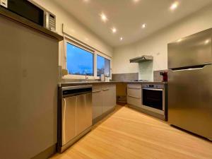 ブザンソンにあるAppartement 9 personnes / 2 Parkings privésのキッチン(ステンレス製の電化製品付)、大きな窓が備わります。