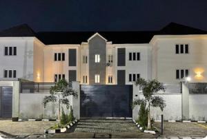 een groot wit huis met 's nachts een poort bij BON Hotel Lekki Residence in Lagos