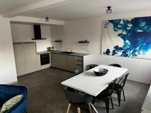 Près colmar 6 : مطبخ وغرفة طعام مع طاولة وكراسي بيضاء