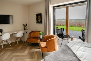 een slaapkamer met een bed en een tafel en stoelen bij B&B de Cley in Noordwijk