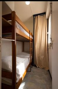 a bedroom with two bunk beds and a window at Studio cabine Les Rives de la Favière piscine et tennis les pieds dans l'eau in Bormes-les-Mimosas